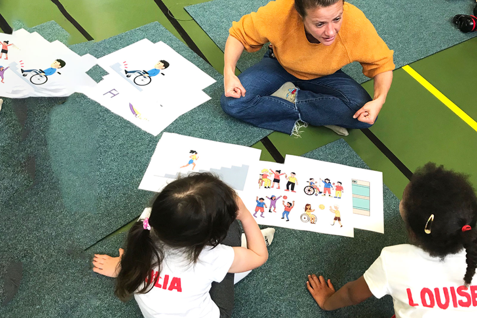 Une femme observe des dessins avec des enfants