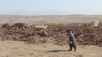 Photo d’archive : Dégâts causés par les trois séismes consécutifs ayant touché la province d'Herat en Afghanistan en octobre 2023. Un homme marche devant un champ de briques et de pierres, restes de bâtiments effondrés.