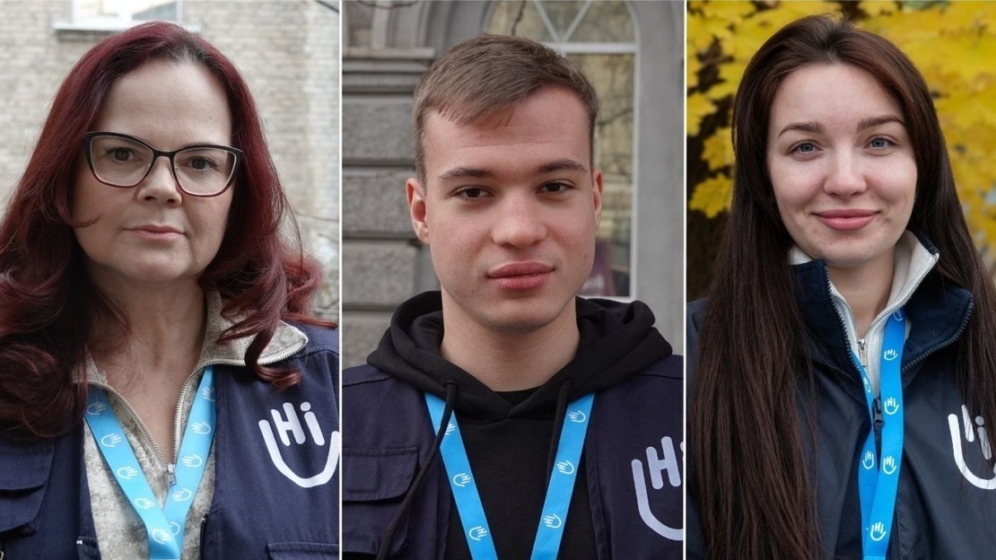 Trois portraits côte à côte montrent des membres de l’organisation humanitaire HI. À gauche, une femme aux cheveux roux et lunettes, portant un gilet bleu avec le logo HI et un badge autour du cou. Au centre, un jeune homme aux cheveux courts, vêtu d’un sweat noir sous son gilet HI. À droite, une jeune femme aux longs cheveux bruns, souriante, avec une veste HI.